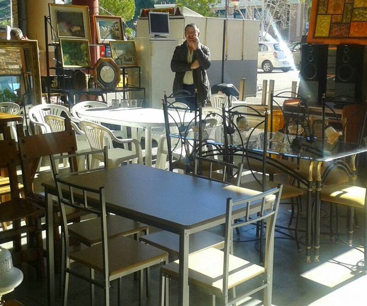 Un hombre de pie en una habitación con mesas y sillas.