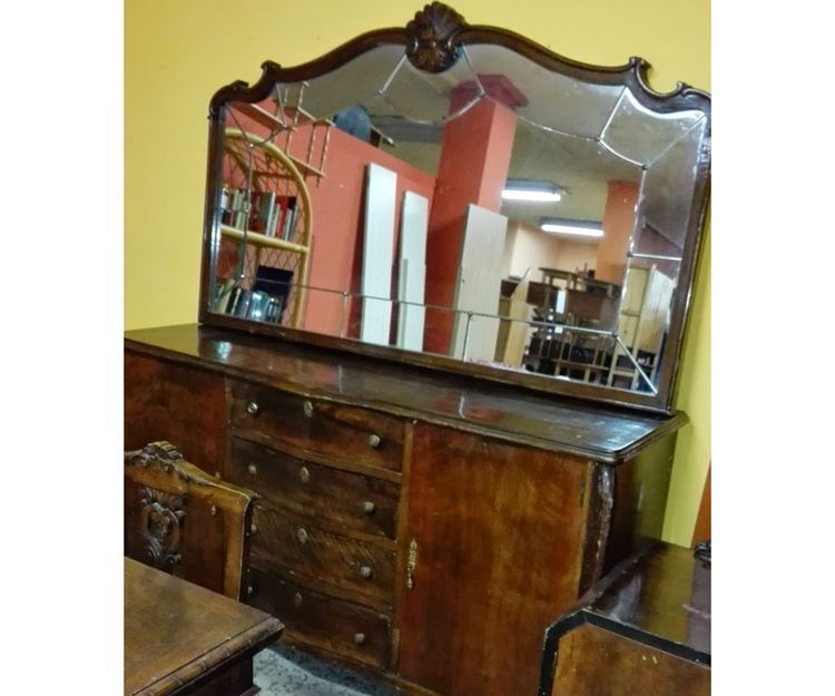 Una cómoda de madera con un gran espejo encima.