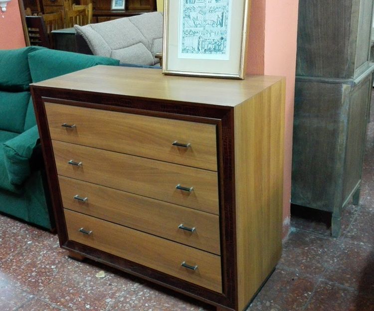Una cómoda de madera con un cuadro encima.