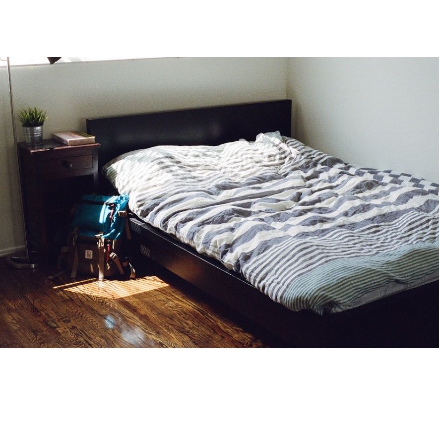 Una cama con un edredón de rayas en un dormitorio.