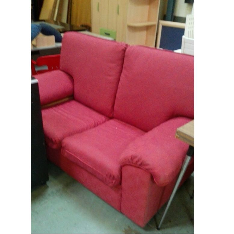 Un sofá rosa está en una habitación con otros muebles.