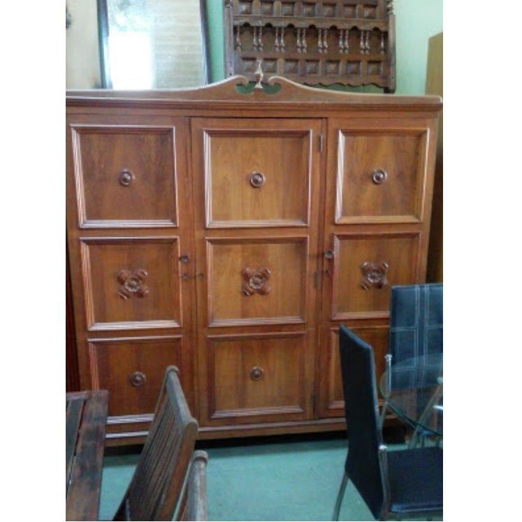 Un gran armario de madera con muchos cajones y puertas.