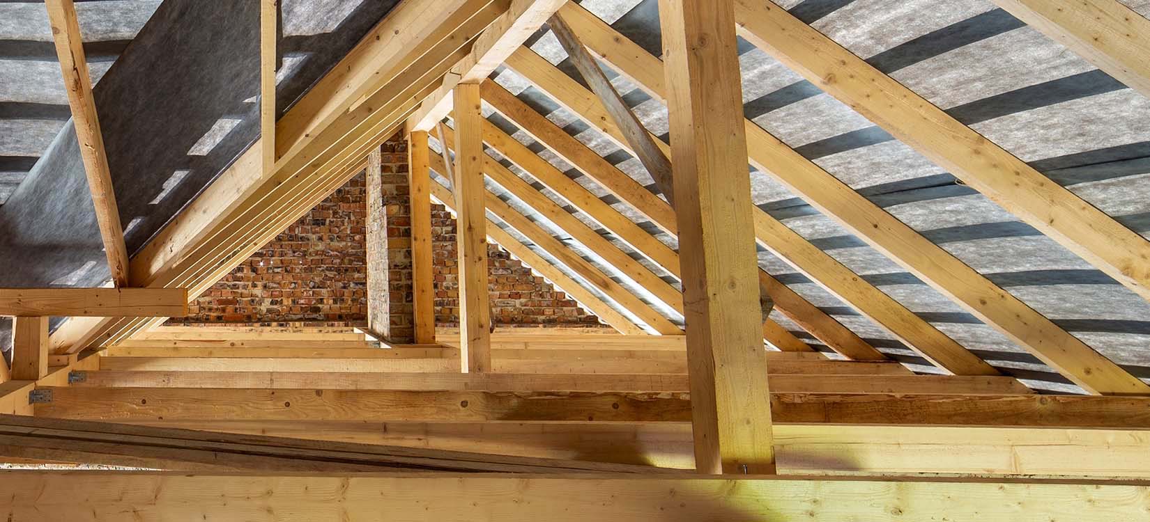 Intérieur sous la charpente avec mur en brique