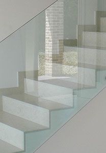 Escalier moderne avec marches en béton et rambarde en verre.