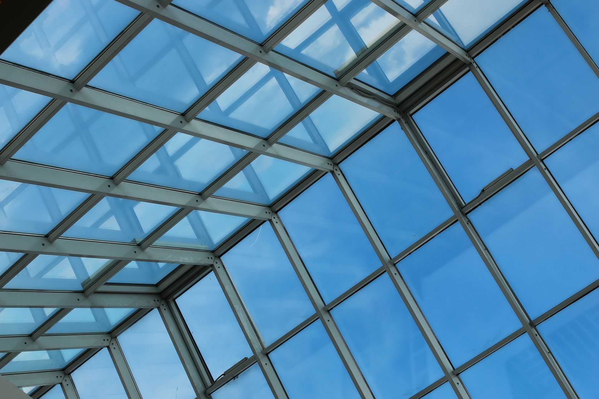 Blick in den Himmel durch ein Gebäude mit vielen Fenstern