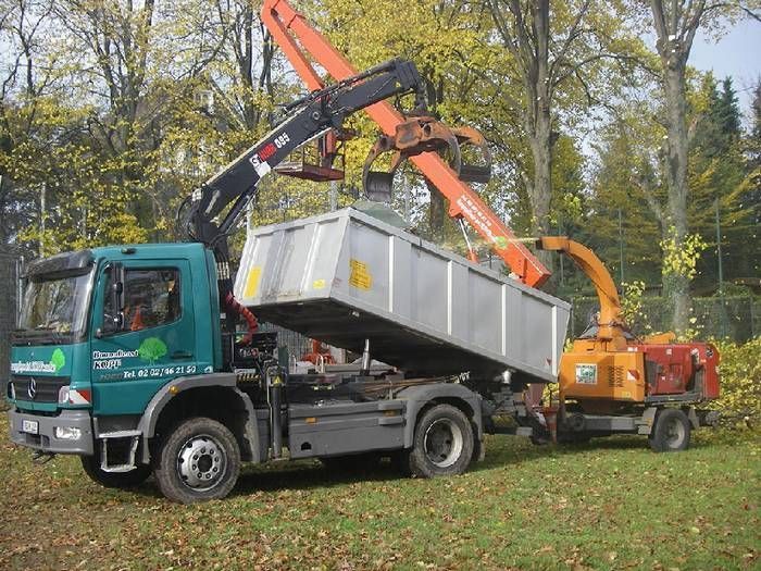 Kipplaster der Firma Baumdienst Kopf neben der Fräse und Hebebühne