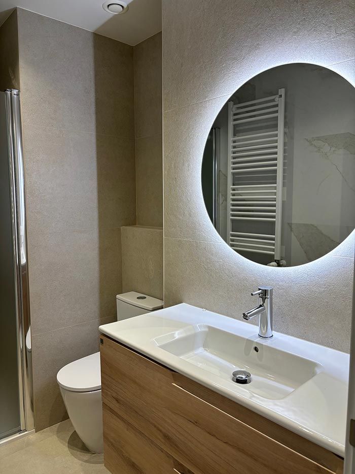 Un baño con inodoro, lavabo y espejo.