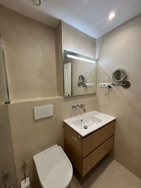 Un baño con inodoro, lavabo y espejo.