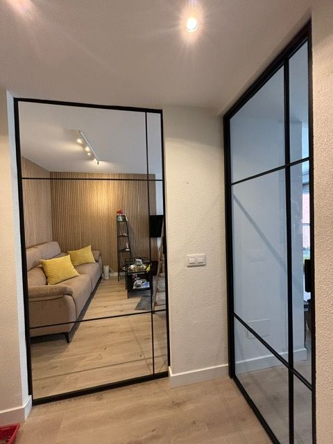 Una sala de estar con un sofá y un espejo grande.