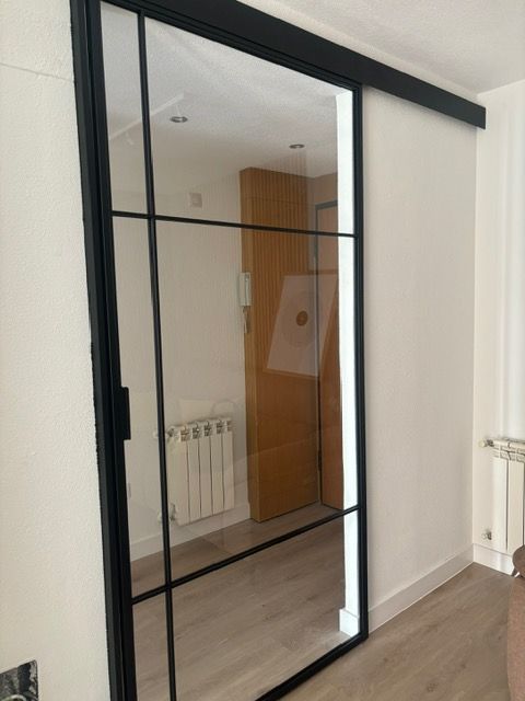 Una puerta corrediza de vidrio con marco negro.