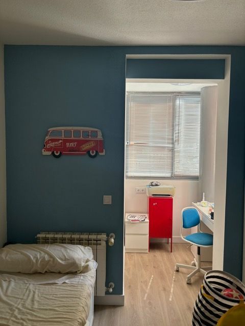 Un dormitorio con una furgoneta roja en la pared encima de la cama.