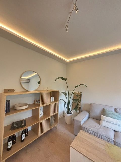 Una sala de estar con un sofá y un espejo.