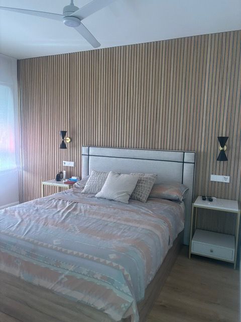 Un dormitorio con una cama y un ventilador de techo.