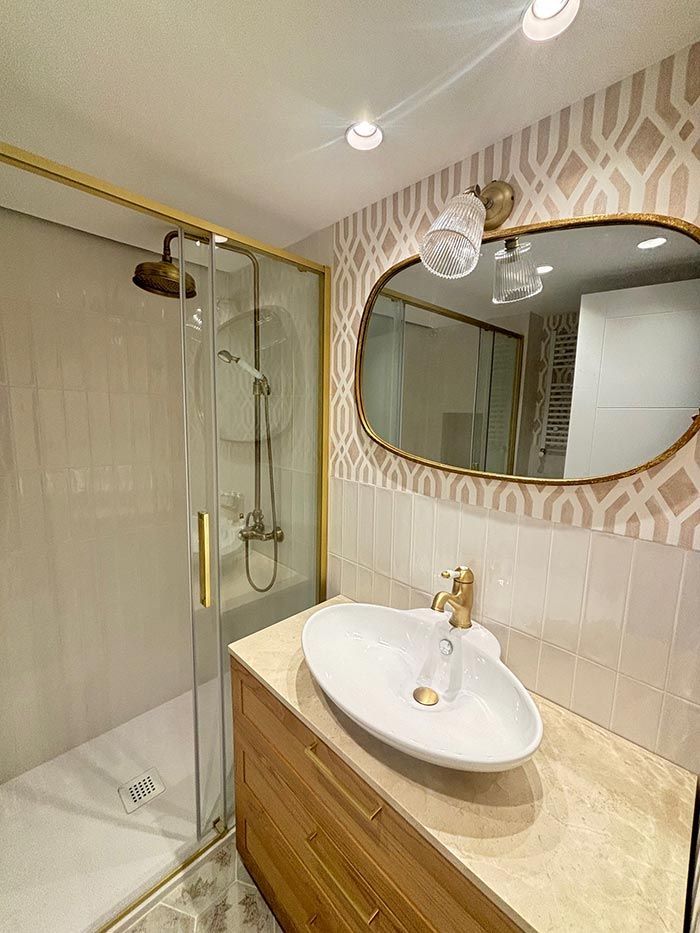 Un baño con lavabo, ducha y espejo.