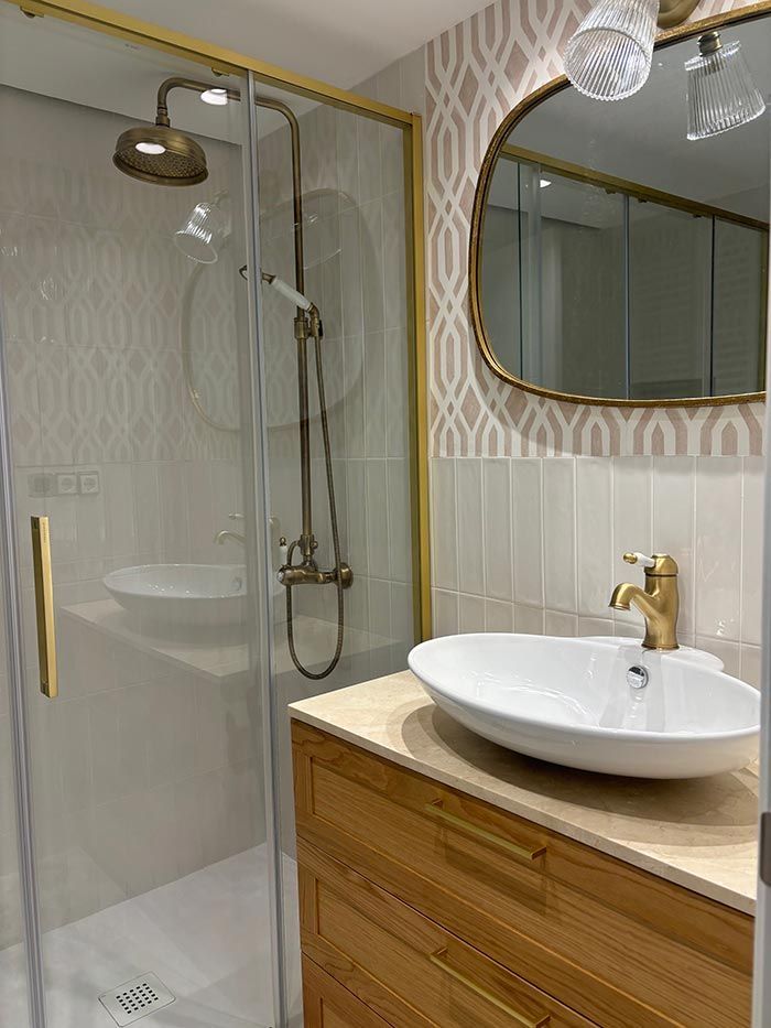 Un baño con lavabo, ducha y espejo.