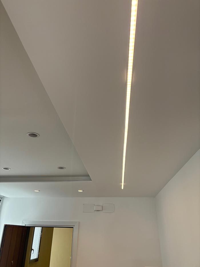 Un techo blanco con una luz que sale de él en una habitación.