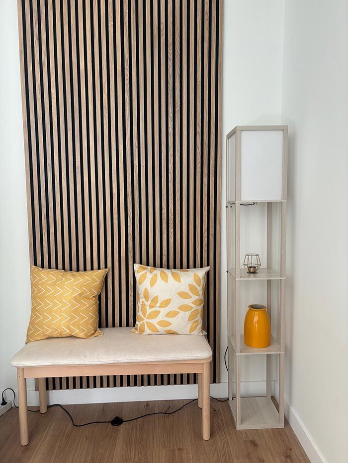 Hay un banco con almohadas amarillas en la esquina de la habitación.