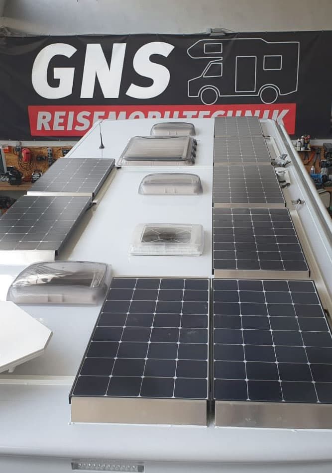 Ein Wohnmobil mit Solarzellen auf dem Dach und einem Schild mit der Aufschrift GNS