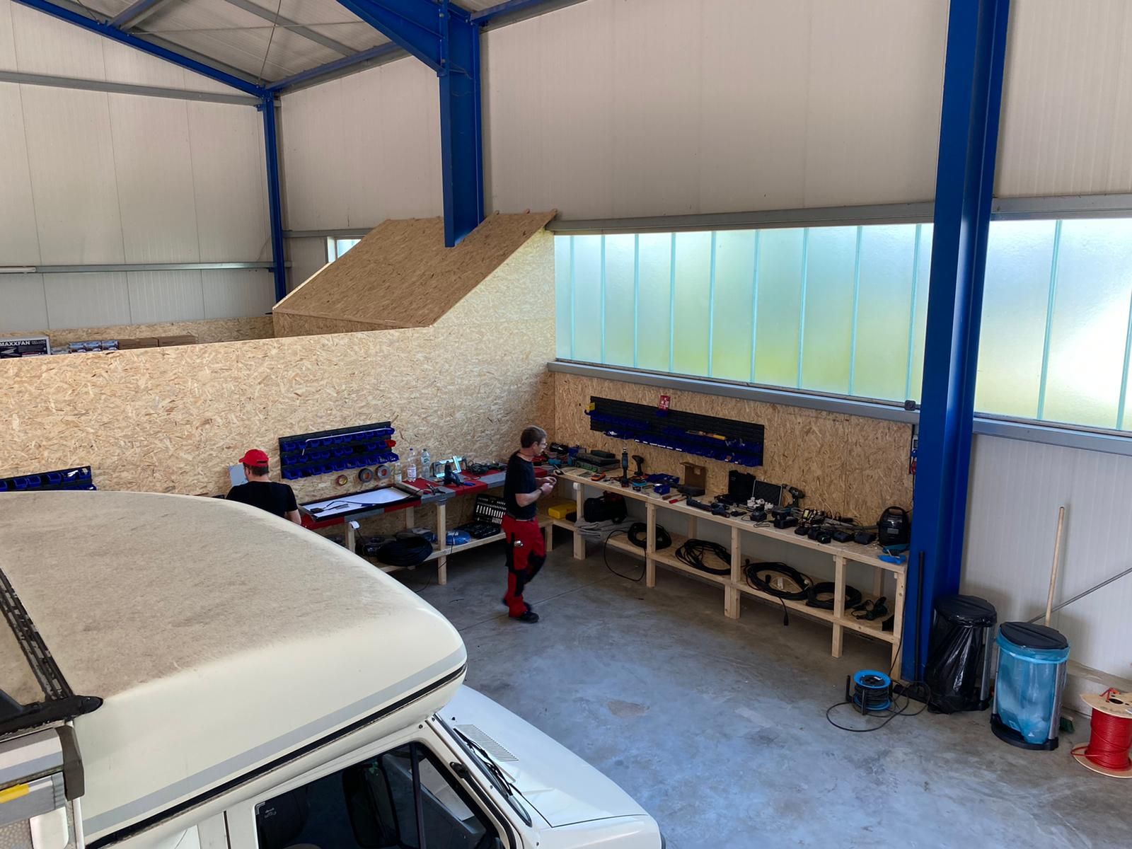 Ein Mann arbeitet in einer Garage an einem Auto.