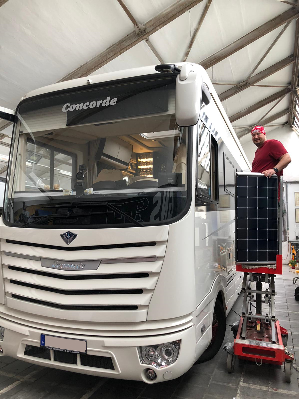 Ein Mann arbeitet in einer Garage an einem Wohnmobil.