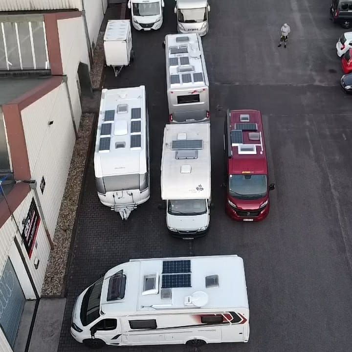 Eine Reihe von Wohnmobilen steht auf einem Parkplatz