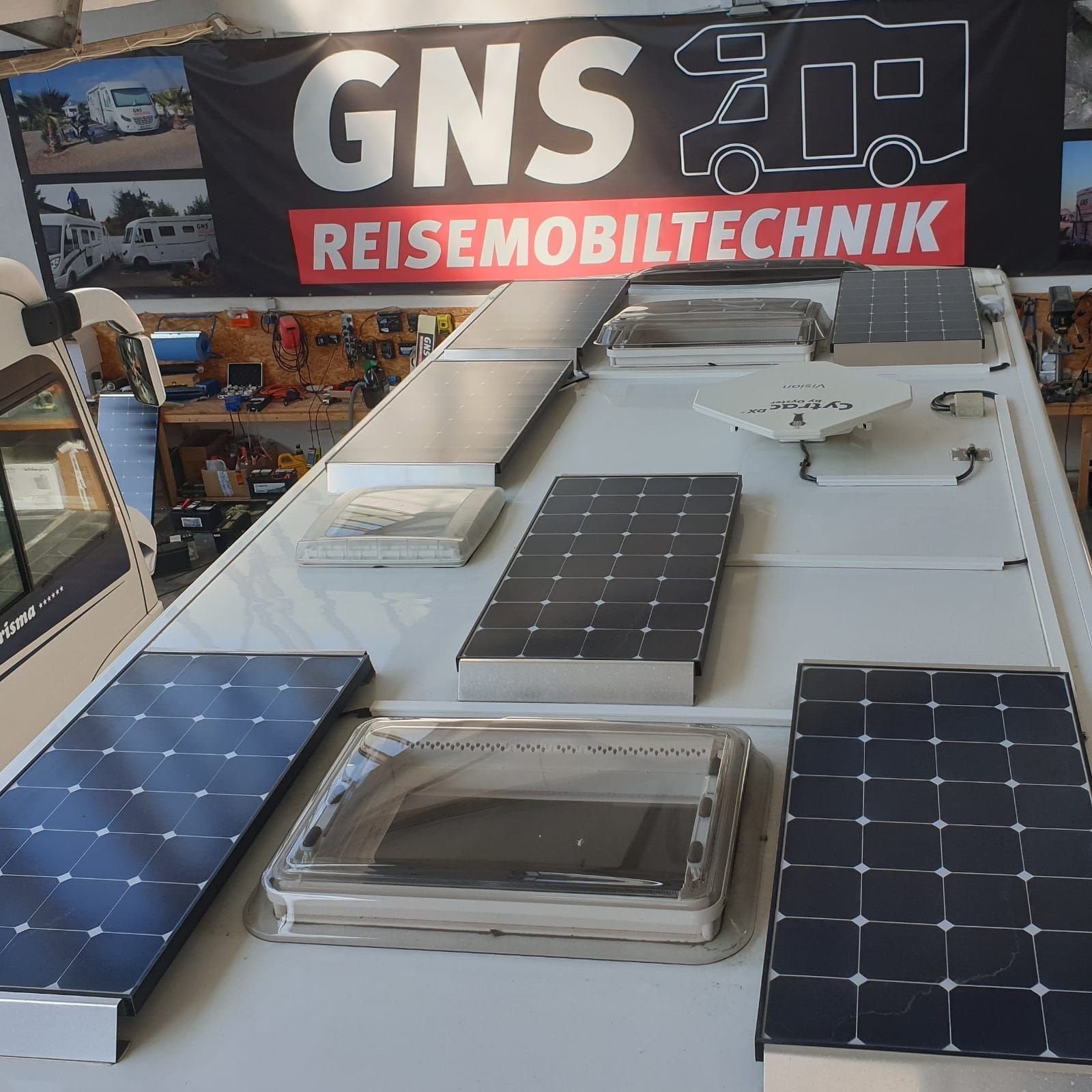 Ein gns reisemobiltechnik Schild hängt über einem Wohnmobil