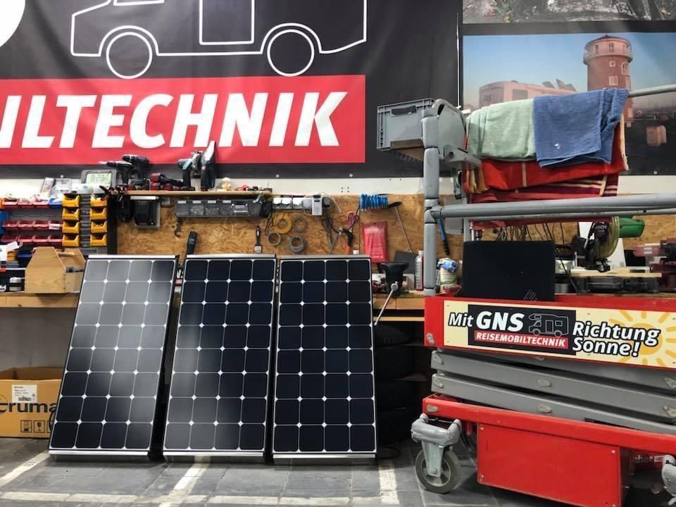 Drei Sonnenkollektoren stehen vor einem Schild mit der Aufschrift „iltechnik“