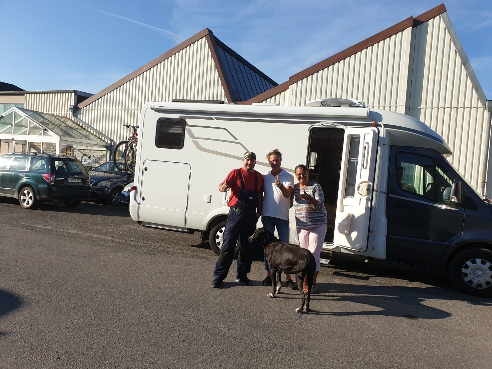 Eine Gruppe von Menschen steht vor einem Wohnmobil