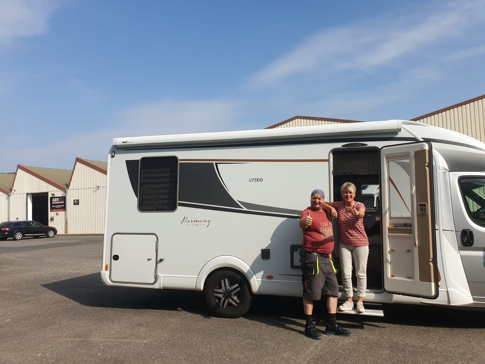 Ein Mann und eine Frau stehen vor einem weißen Wohnmobil