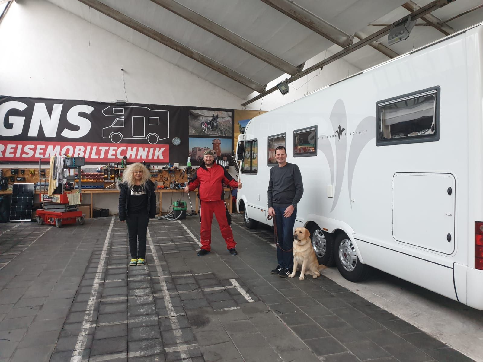 Eine Gruppe von Menschen steht vor einem GNS-Schild