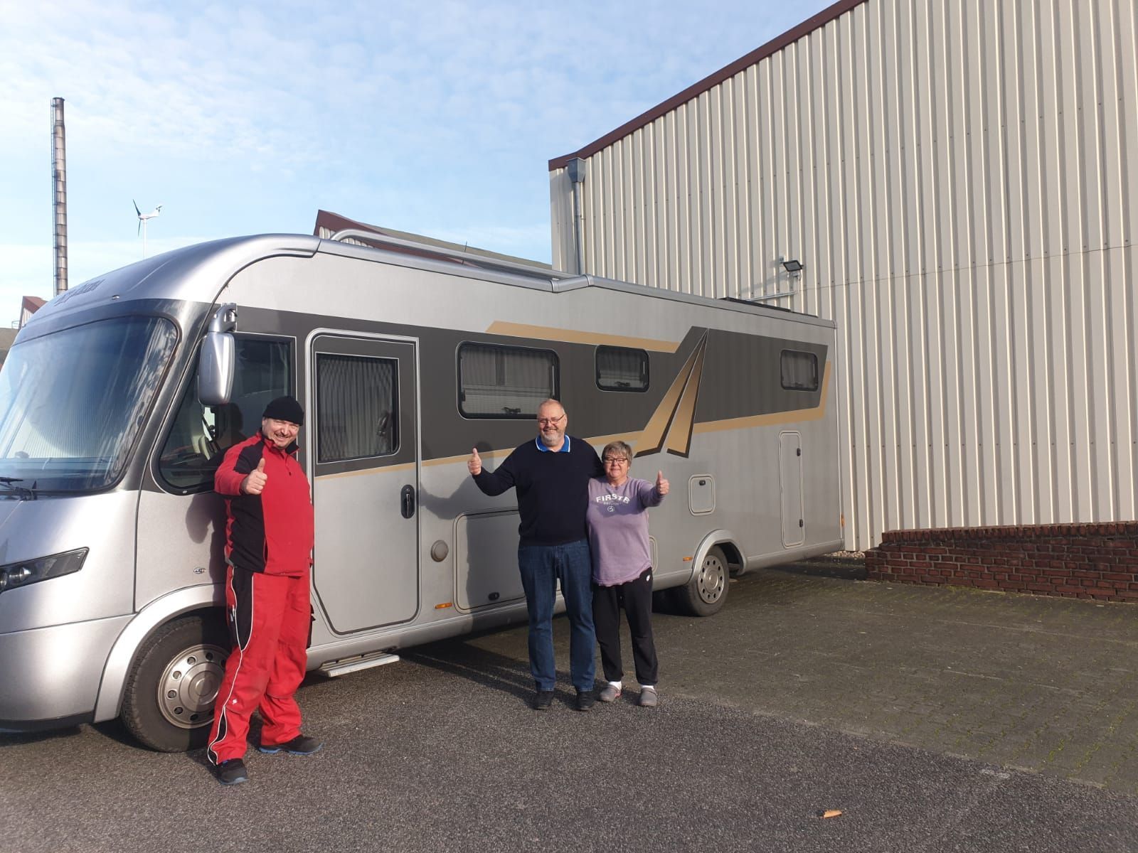 Eine Gruppe von Menschen steht vor einem Wohnmobil