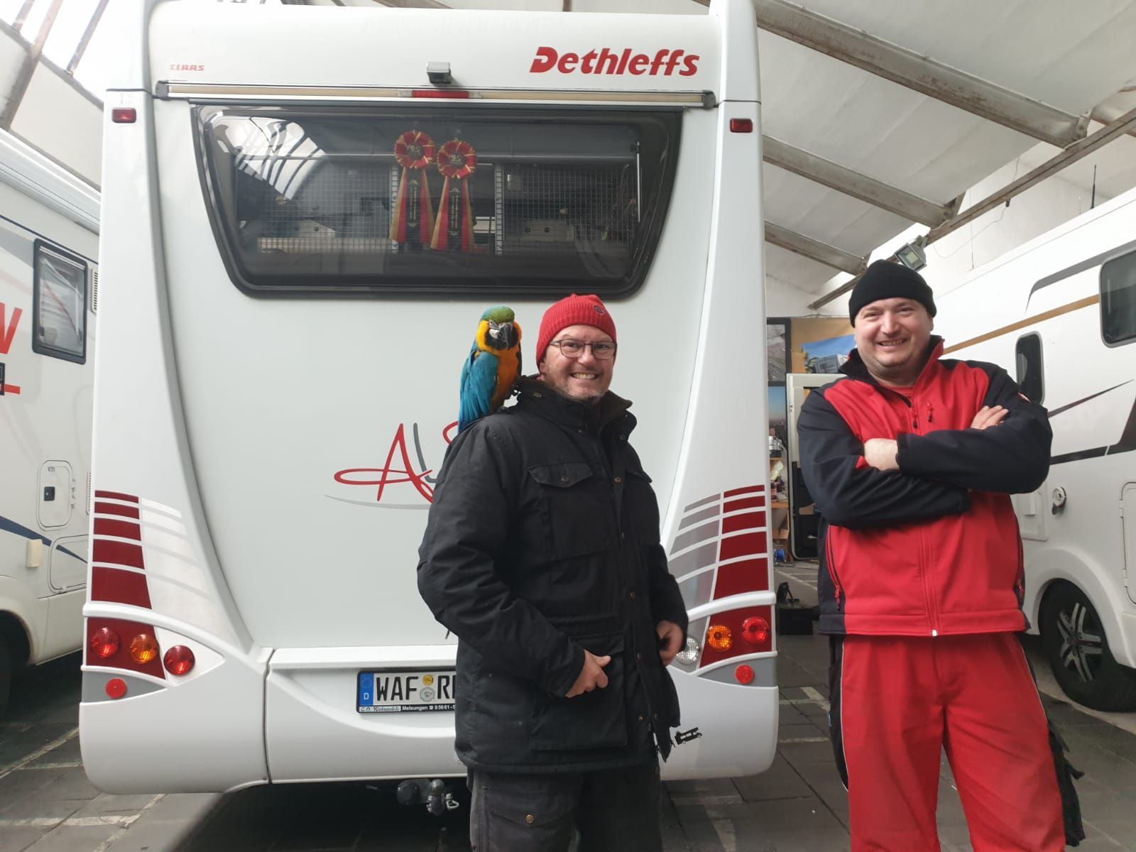 Zwei Männer stehen vor einem Wohnmobil mit der Aufschrift Dethleffs