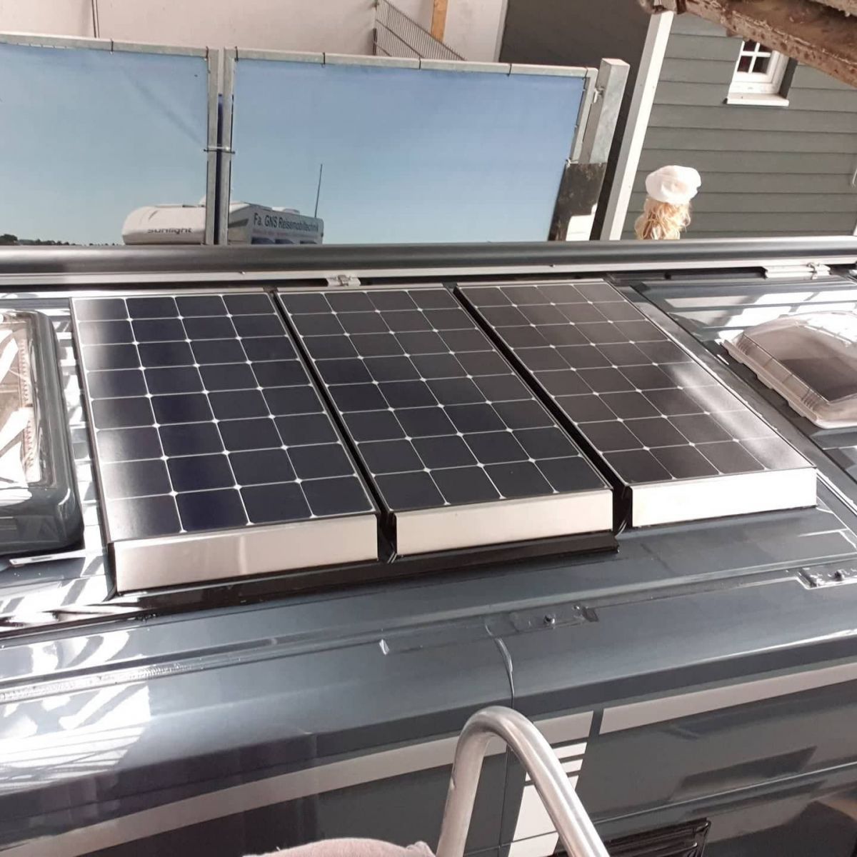 Auf dem Dach eines Lieferwagens befinden sich drei Solarmodule.