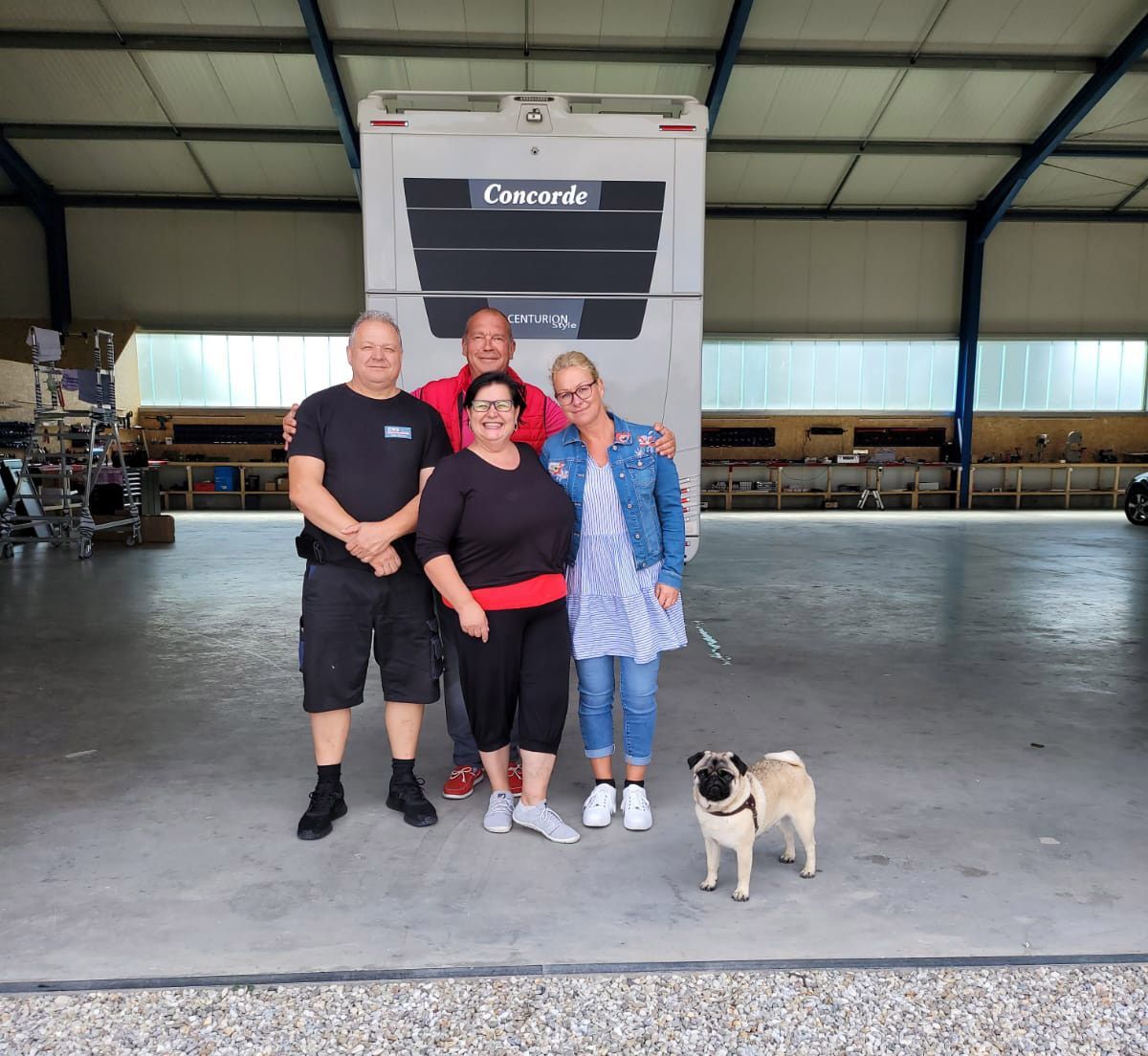 Eine Gruppe von Menschen posiert für ein Foto mit einem Mops