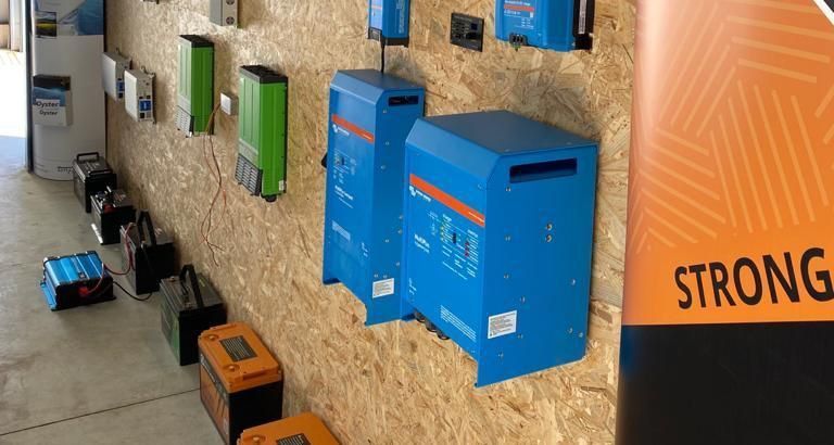 Eine Reihe blauer und grüner Kisten, die an einer Holzwand hängen.
