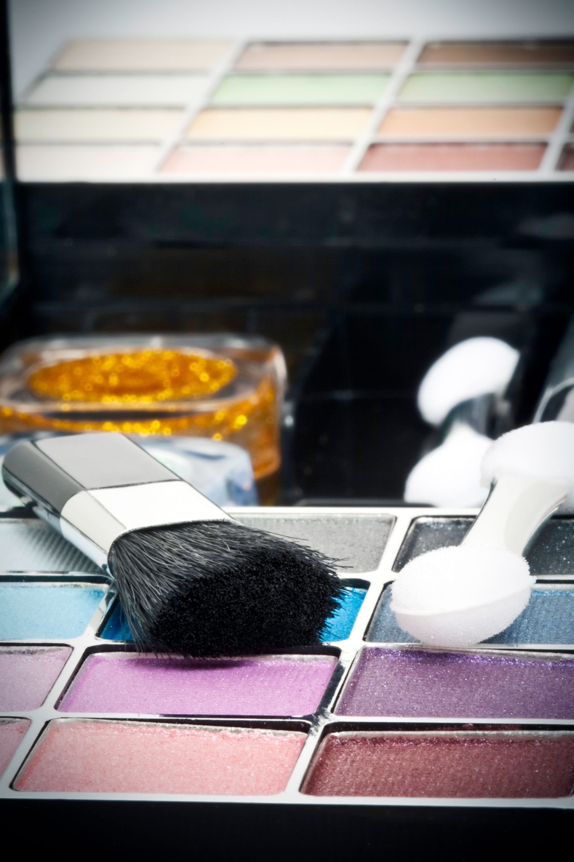 Une esthéticienne passant du produit avec un pinceau sur le visage d'une femme