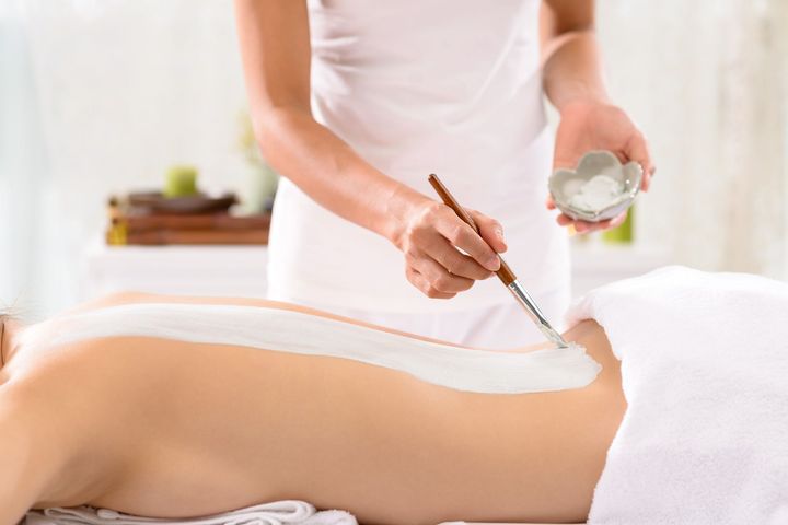 Passage de produit au pinceau sur le dos d'une femme