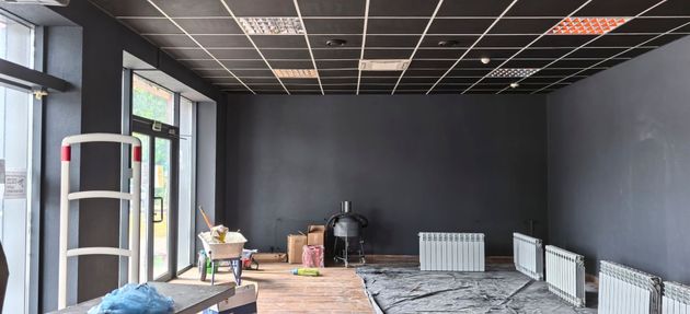 Ein unmöbliertes, derzeit renoviertes Zimmer verfügt über anthrazitgraue Wände.