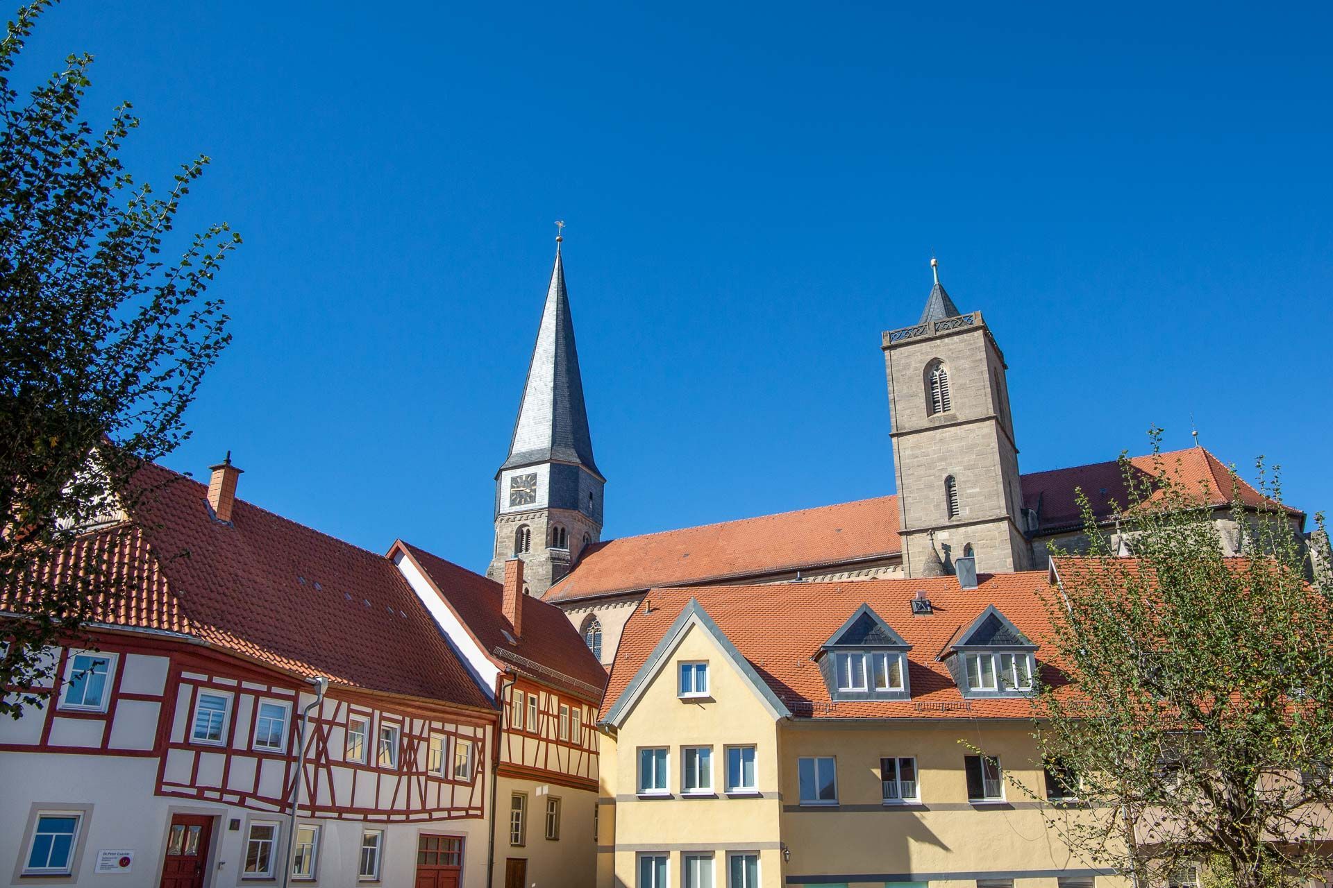 Fachwerkensemble mit der Münnerstädter Stadtpfarrkirche im Hintergrund