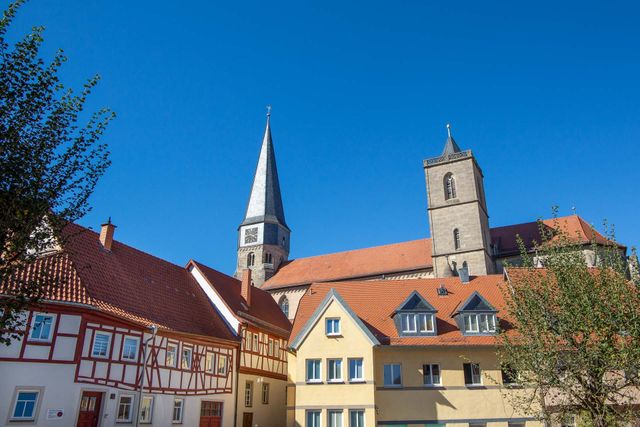 Fachwerkensemble mit der Münnerstädter Stadtpfarrkirche im Hintergrund