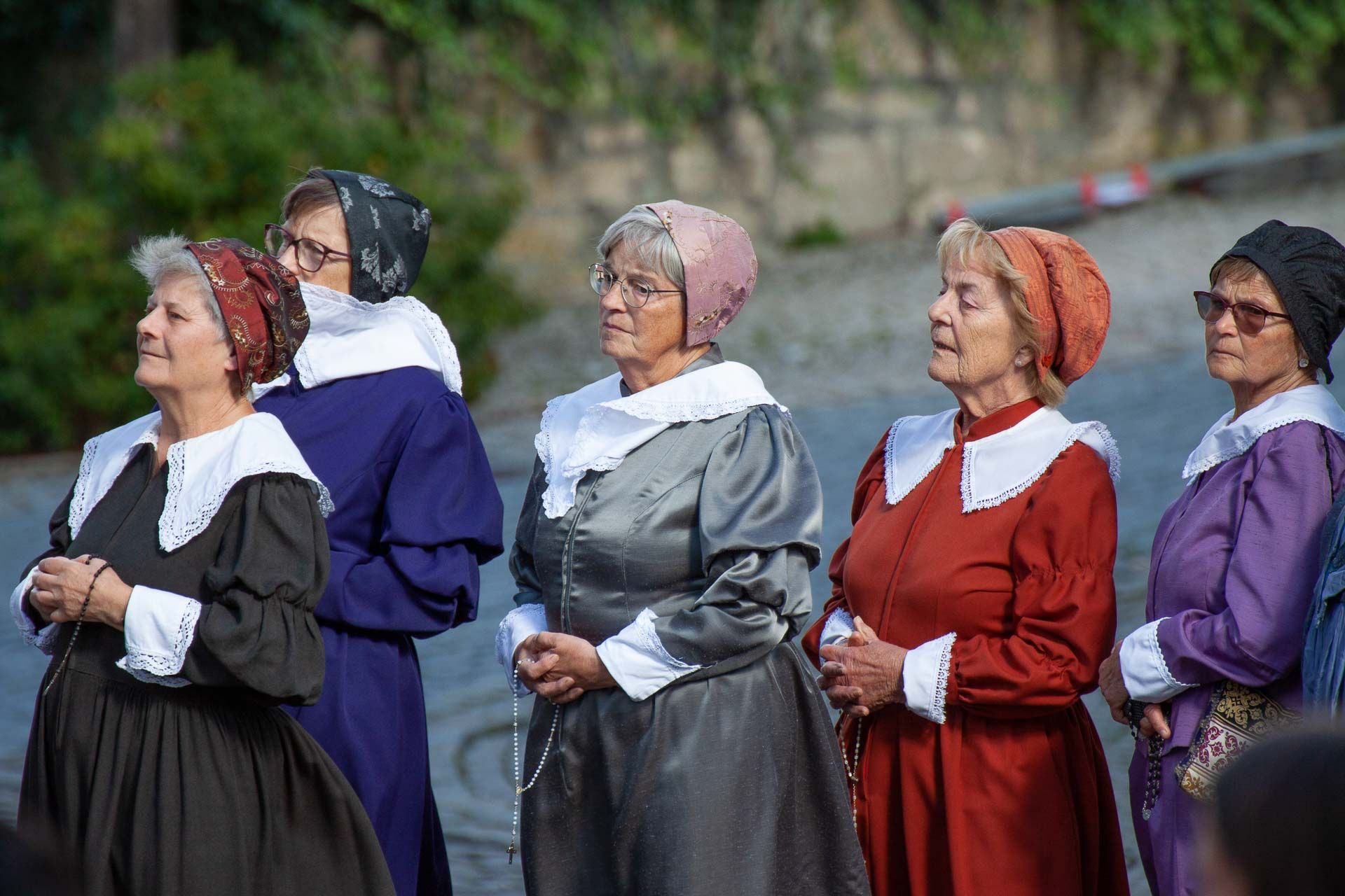 Szene aus dem Heimatspiel mit mehreren betenden Frauen in Kleidern mit weißem Kragen und passenden Hauben