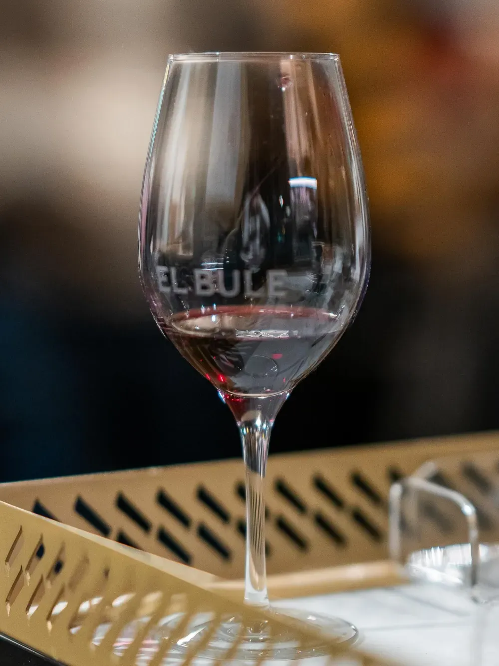 Una copa de vino vacía sobre la mesa de un restaurante con el fondo desenfocado.