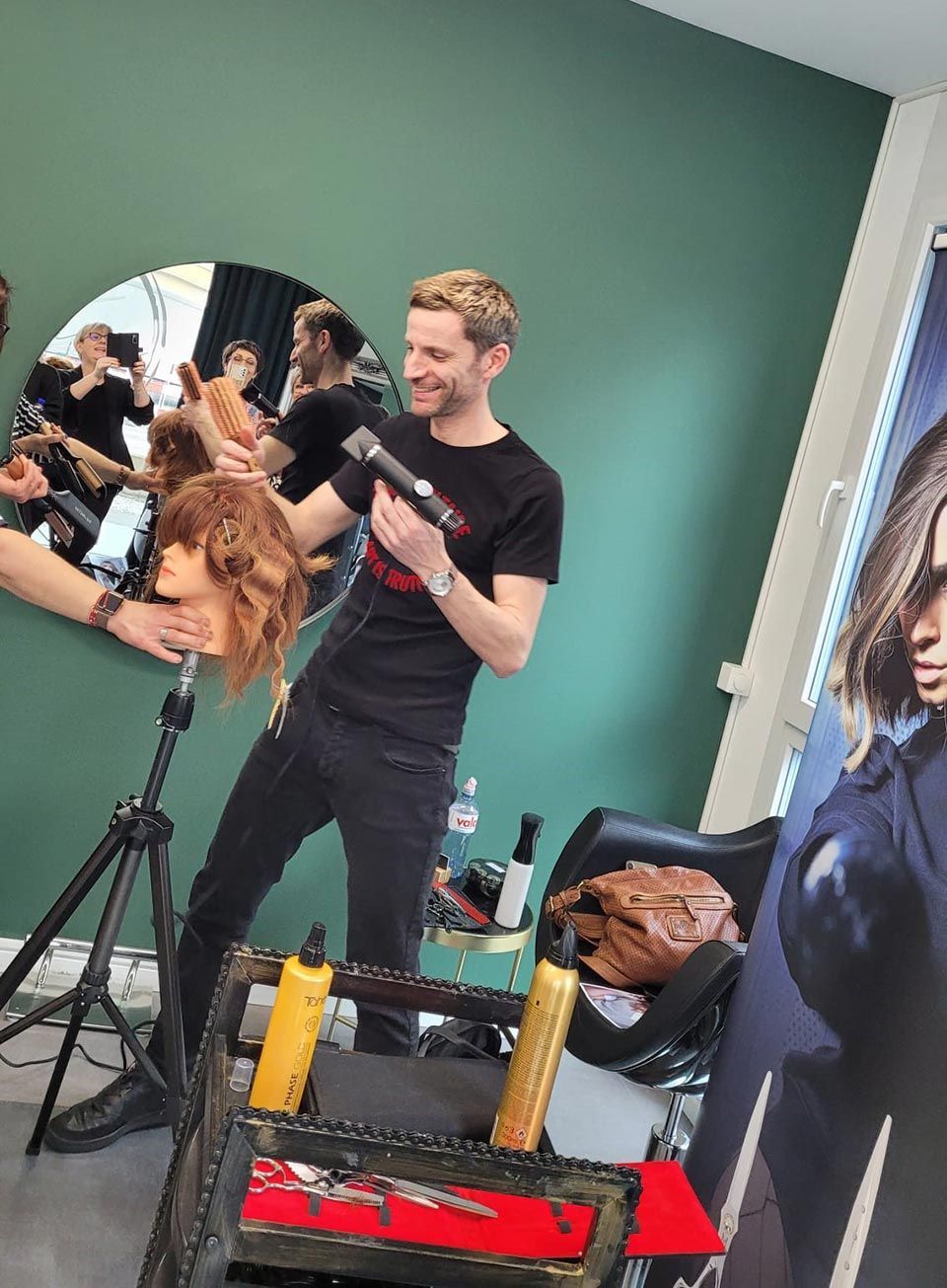 Ein Mann föhnt die Haare einer Schaufensterpuppe.
