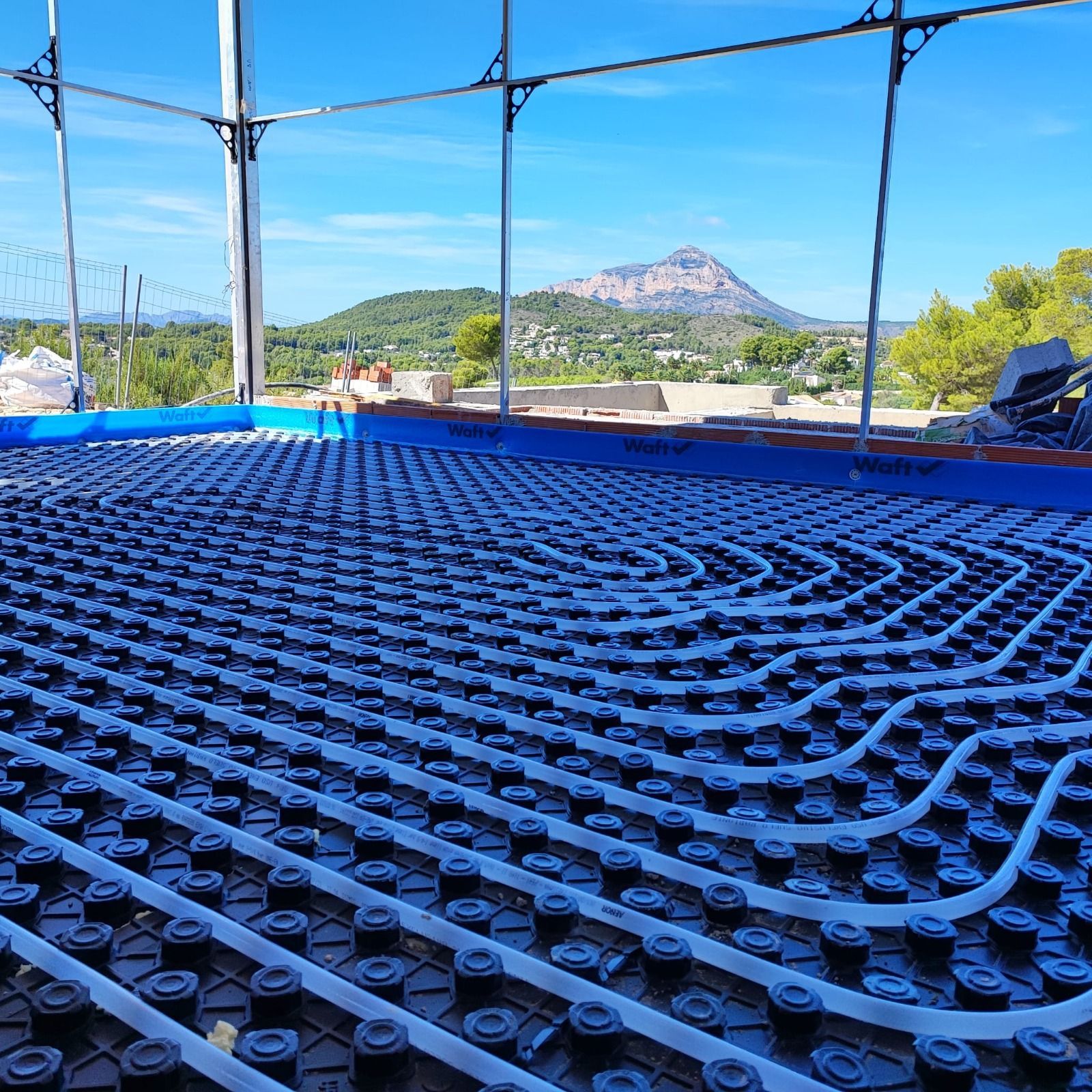Un edificio en construcción con una montaña al fondo.