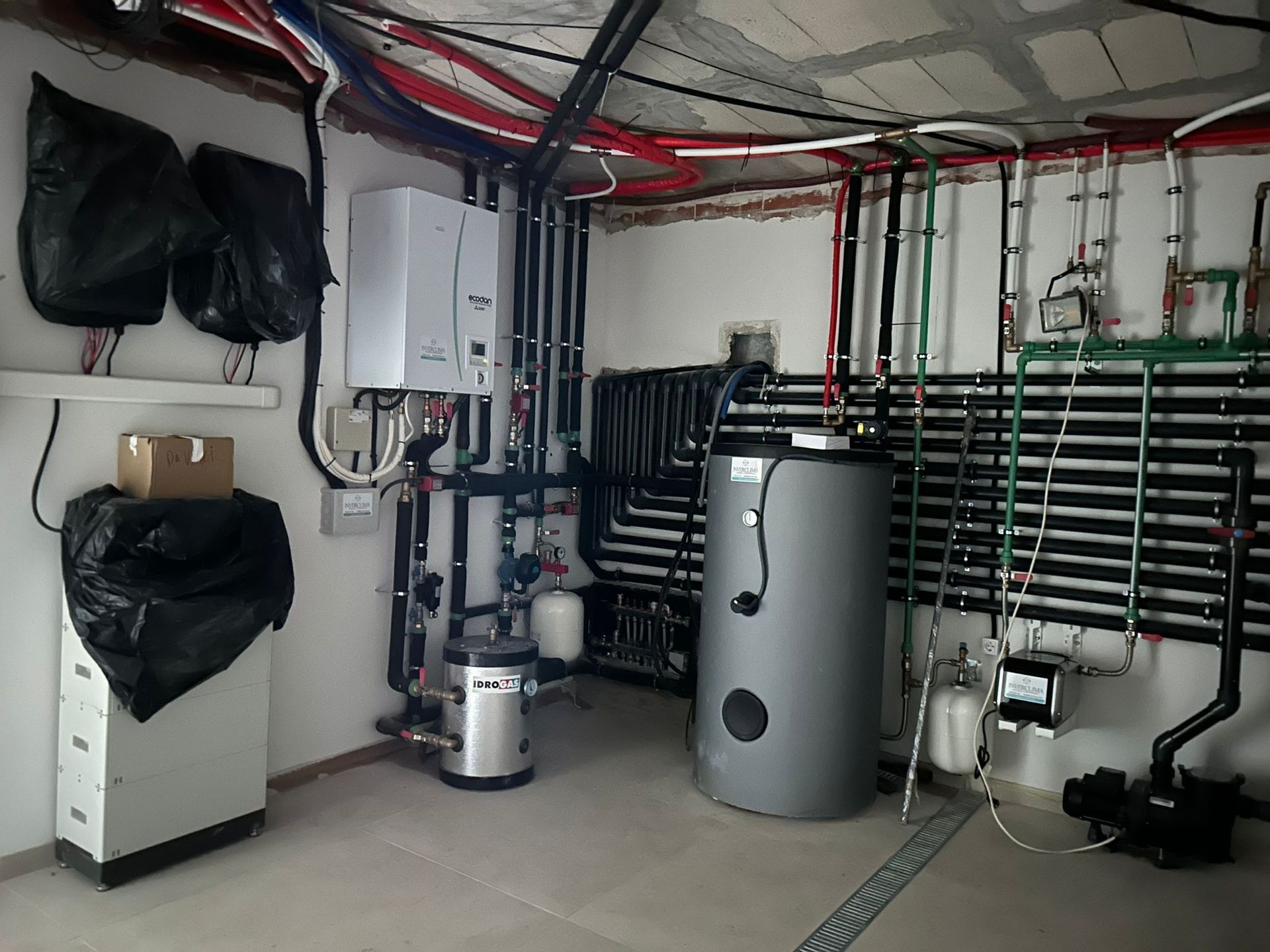 Una habitación con muchas tuberías y un calentador.