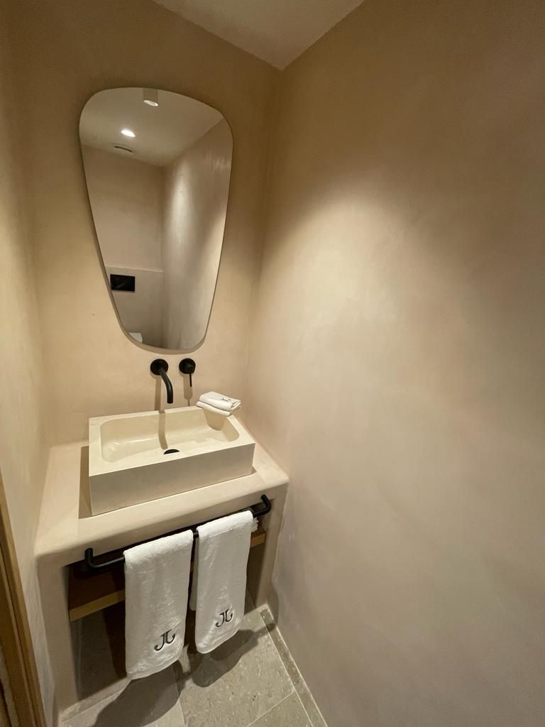 Un baño con lavabo, espejo y toallas.