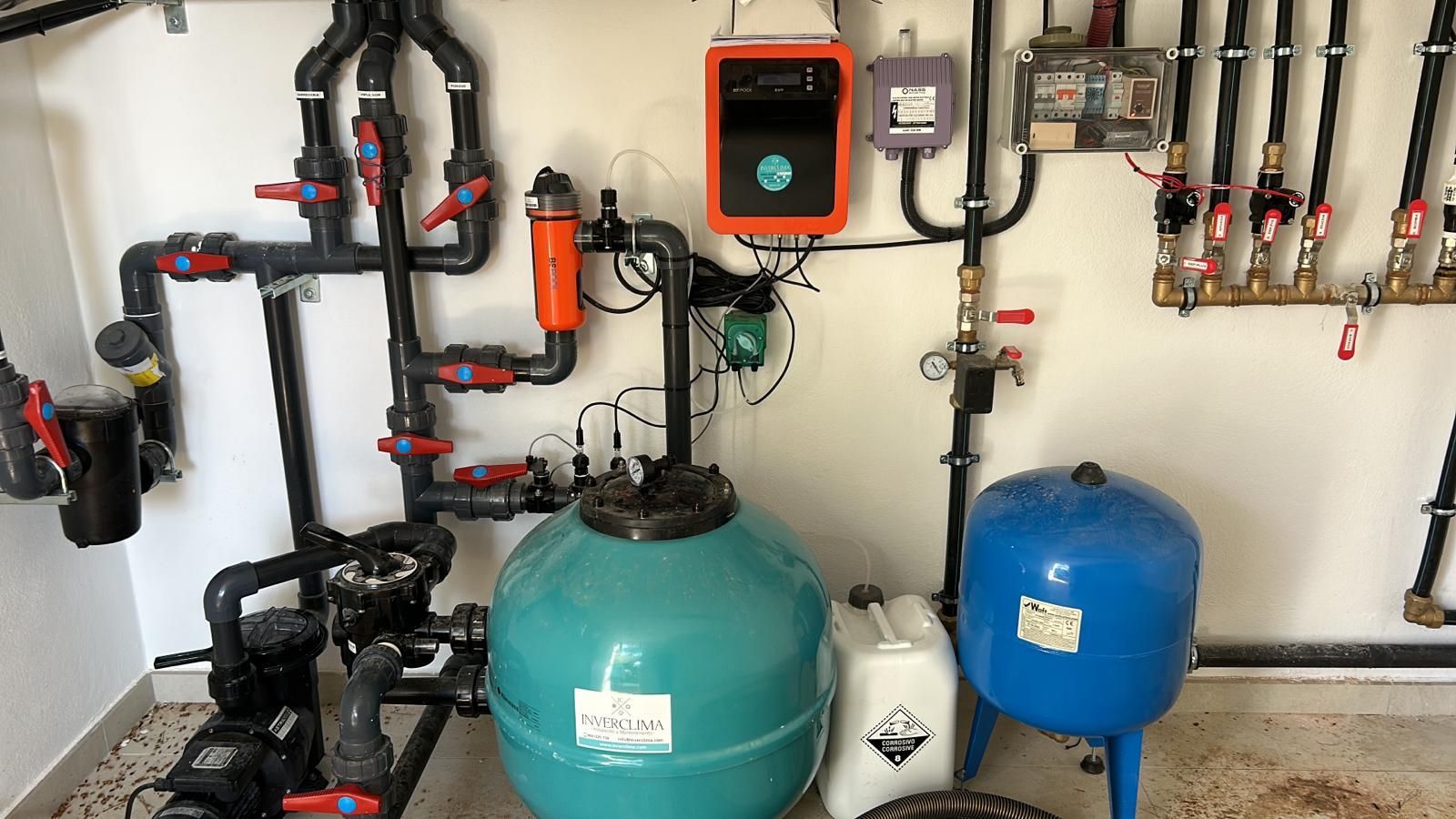 Una habitación con muchas tuberías y tanques en la pared.