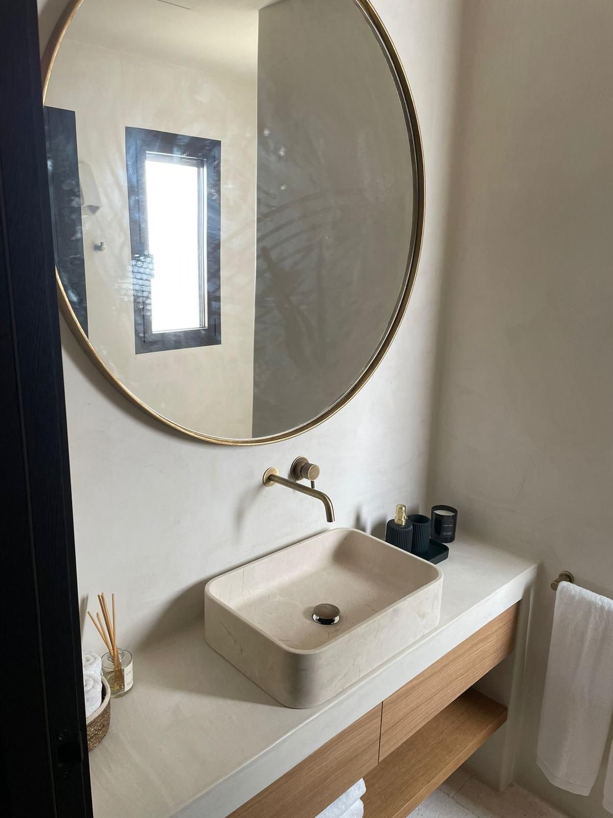 Un baño con lavabo, espejo y ventana.