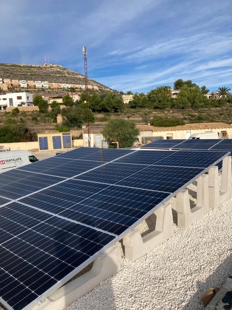 Hay muchos paneles solares en el tejado de un edificio.