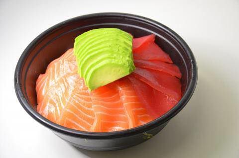 Bol de sashimi de saumon et de thon garni d'avocat.